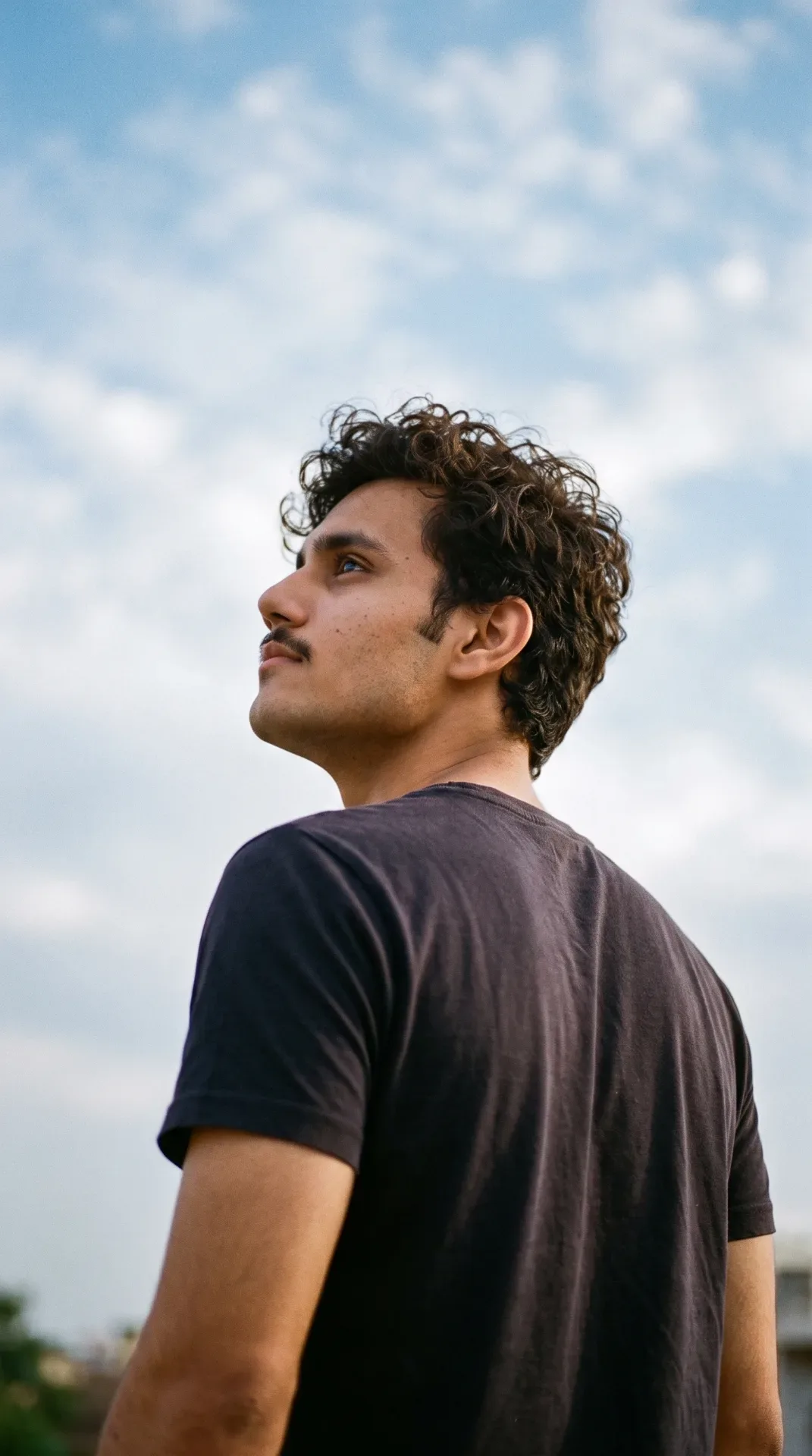 Young Man Looking Upward Against Blue Sky AI Photo Prompt preview example result
